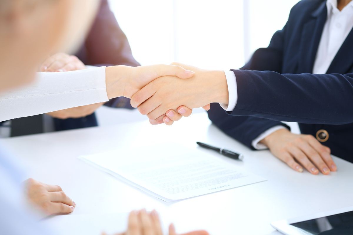 Group of business people or lawyers shaking hands finishing up a meeting , close-up. Success at negotiation and handshake concepts